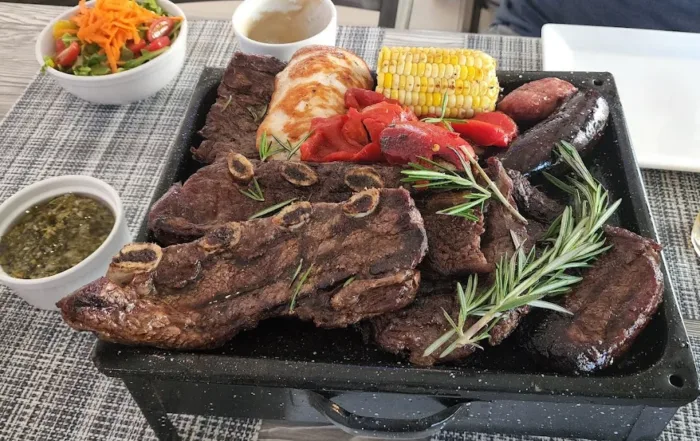 Assorted Grilled meats on a cart with chimichuri sauce and orange juice