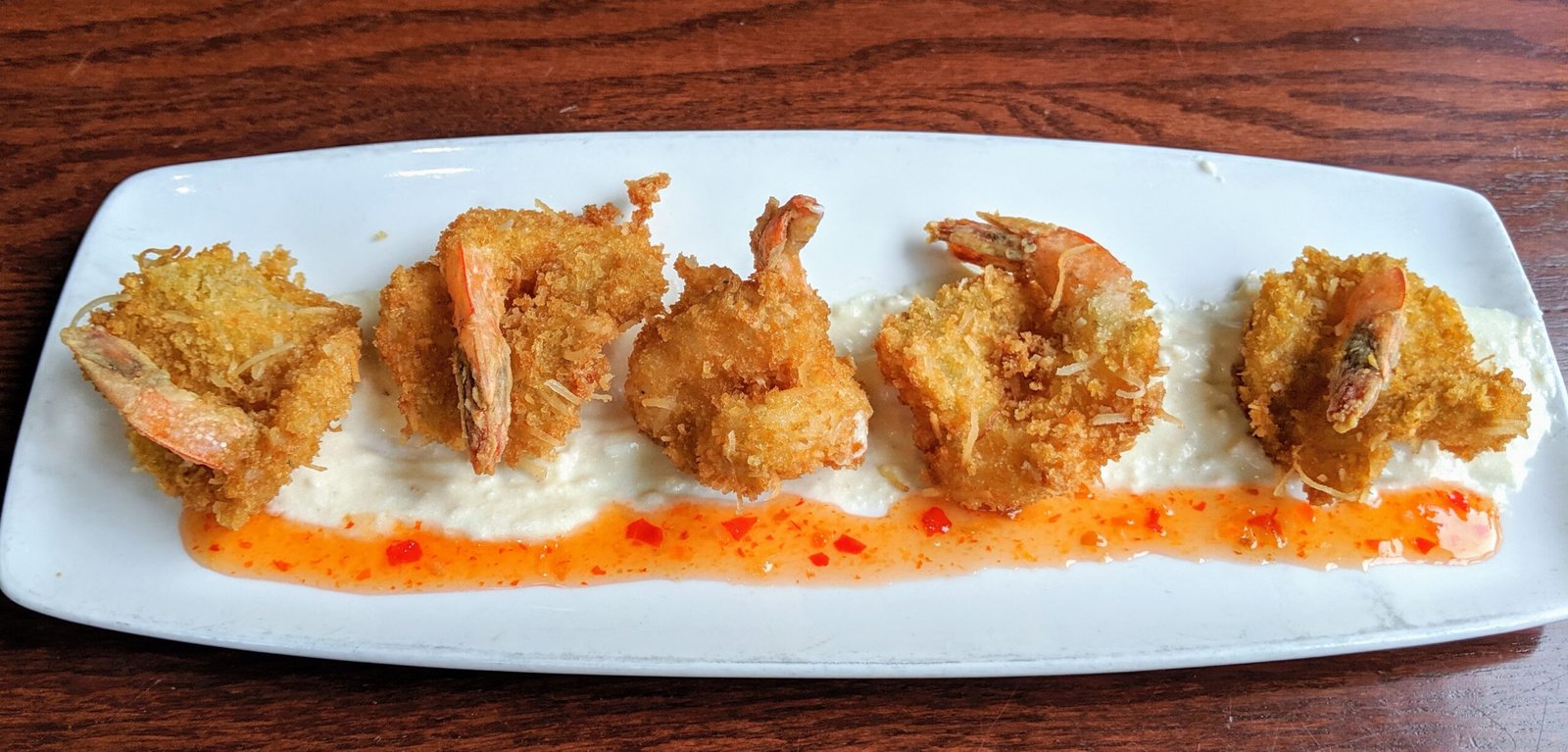 5 coconut batter fried shrimp ove a coconut and sweet chili sauce