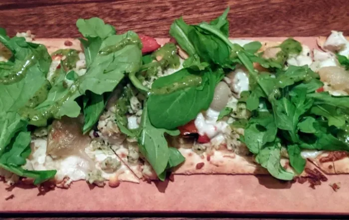 Flat bread with arugala on a board
