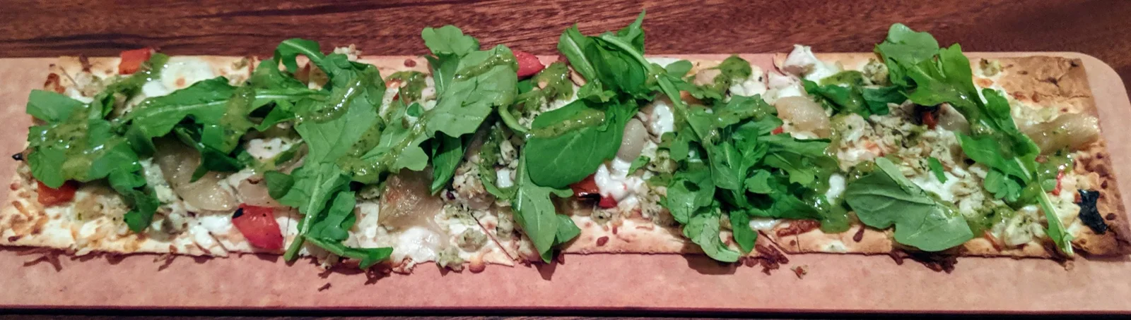 Flat bread with arugala on a board