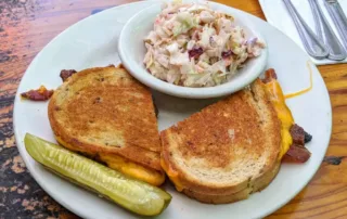 Grilled Cheese with bacon a pickle and coleslaw