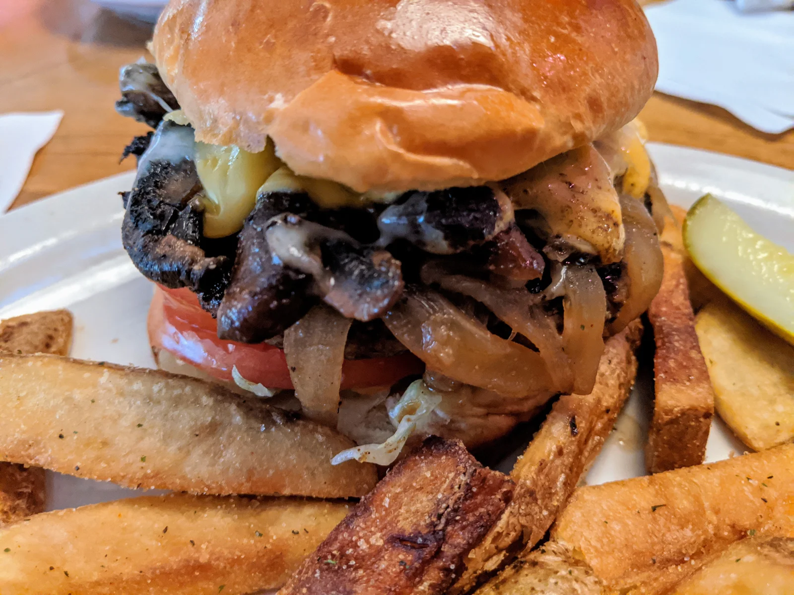 a huge mushroom swiss burger and steak fries