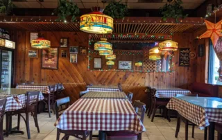 Wood Panel Dining Room with stained Glass Lights and Checkered Table Cloths