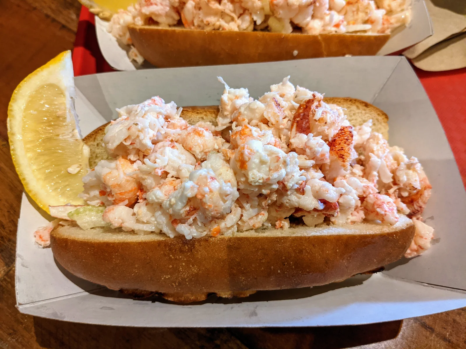 a lobster roll with a lemon wedge
