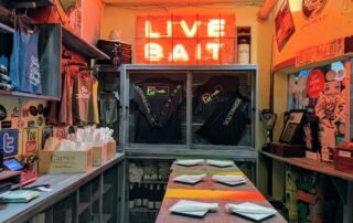 Reserved Table at Papa's Raw bar. Neon Live Bait sign over table.