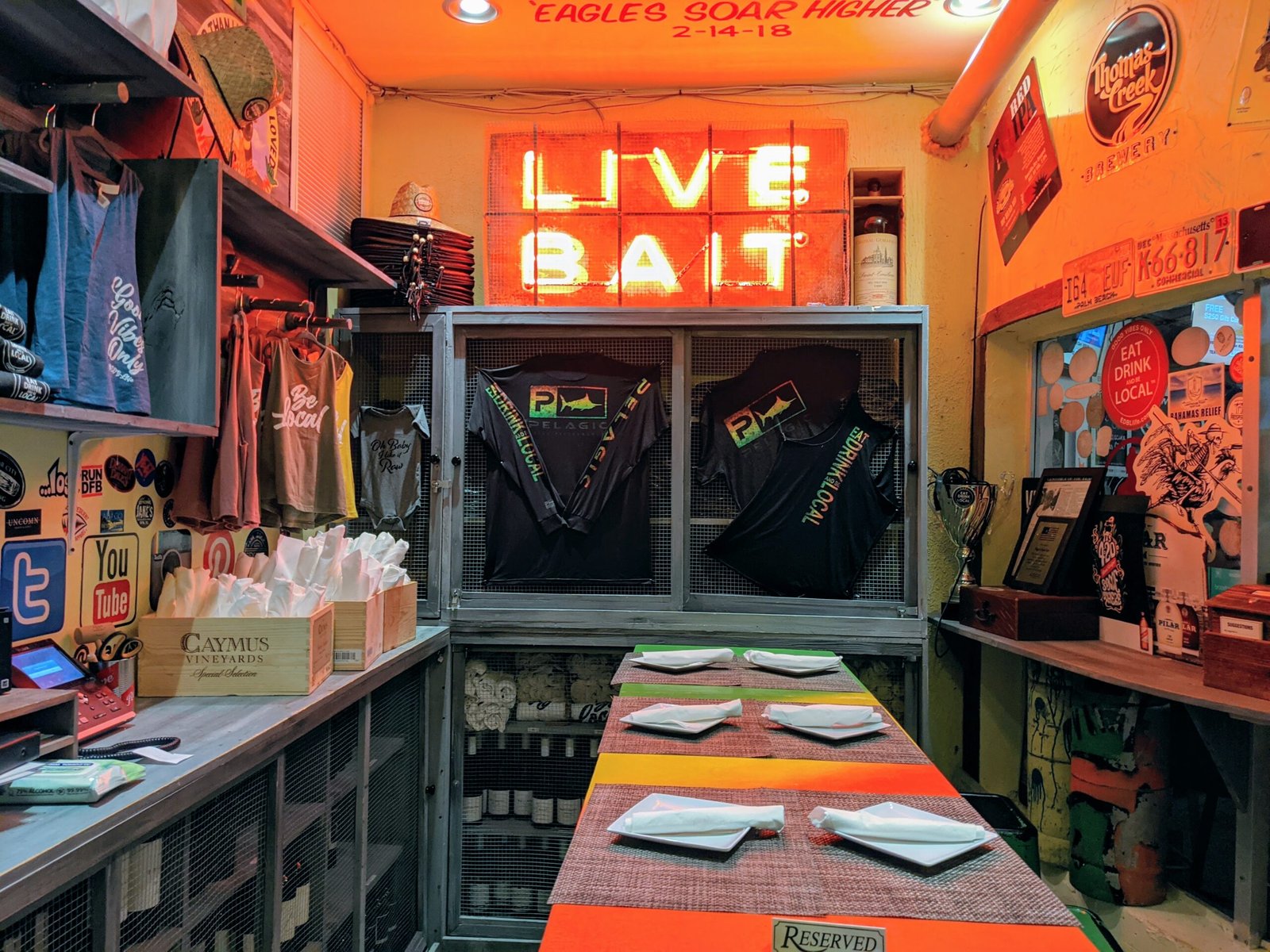 Reserved Table at Papa's Raw bar. Neon Live Bait sign over table.