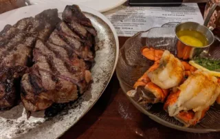 Grilled new York Strip Steak with a pair of Broiled Lobster Tails