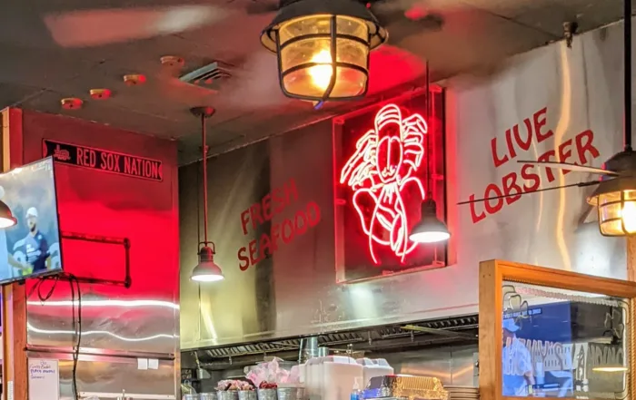 Neon Lobster sign hanging over kitchen in Kelly's