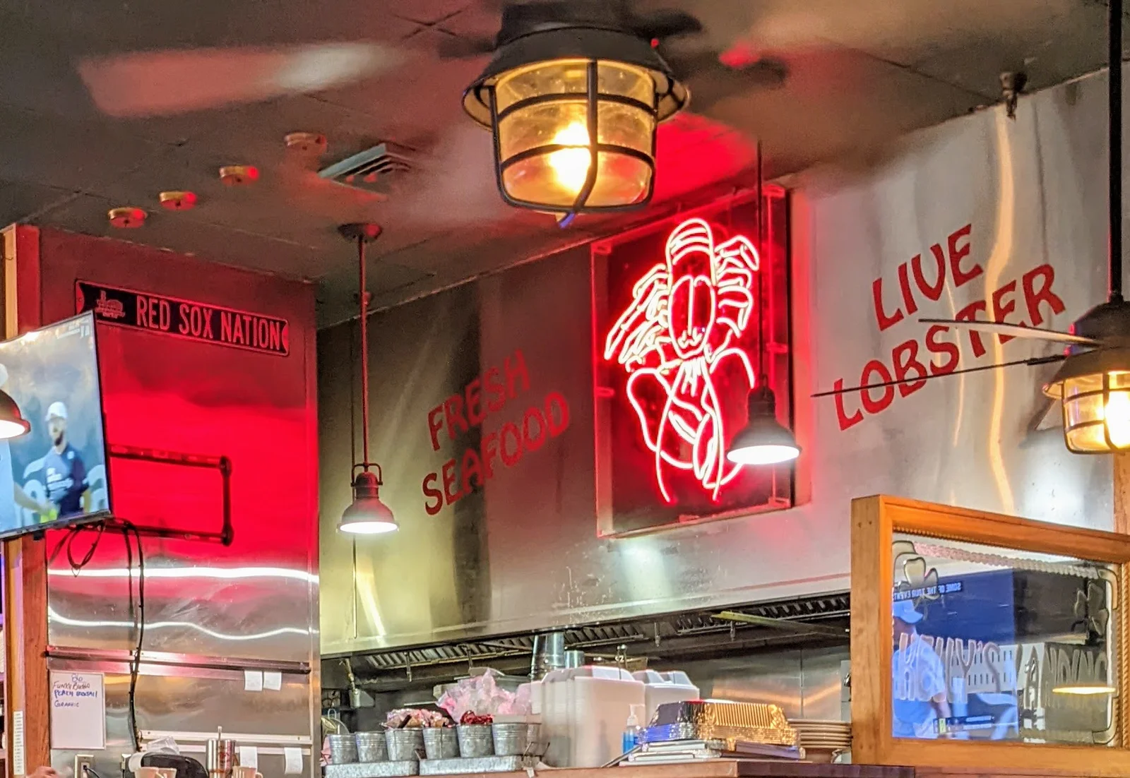 Neon Lobster sign hanging over kitchen in Kelly's