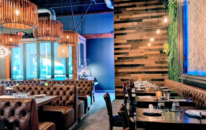 The dining room of SEA Kitchen leather booths and wood panel walls