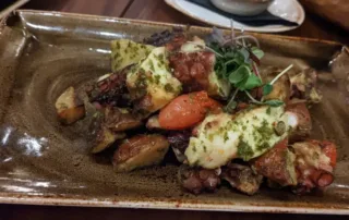 Grilled Octopus Salad topped with Greens