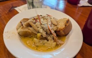 Shelled Crab Claws in a garlic sauce over bread