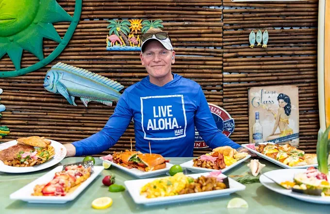 Owner of Kay with mutiple dishes on a table