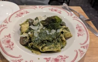 Pasta topped with a pesto sauce and Mushrooms