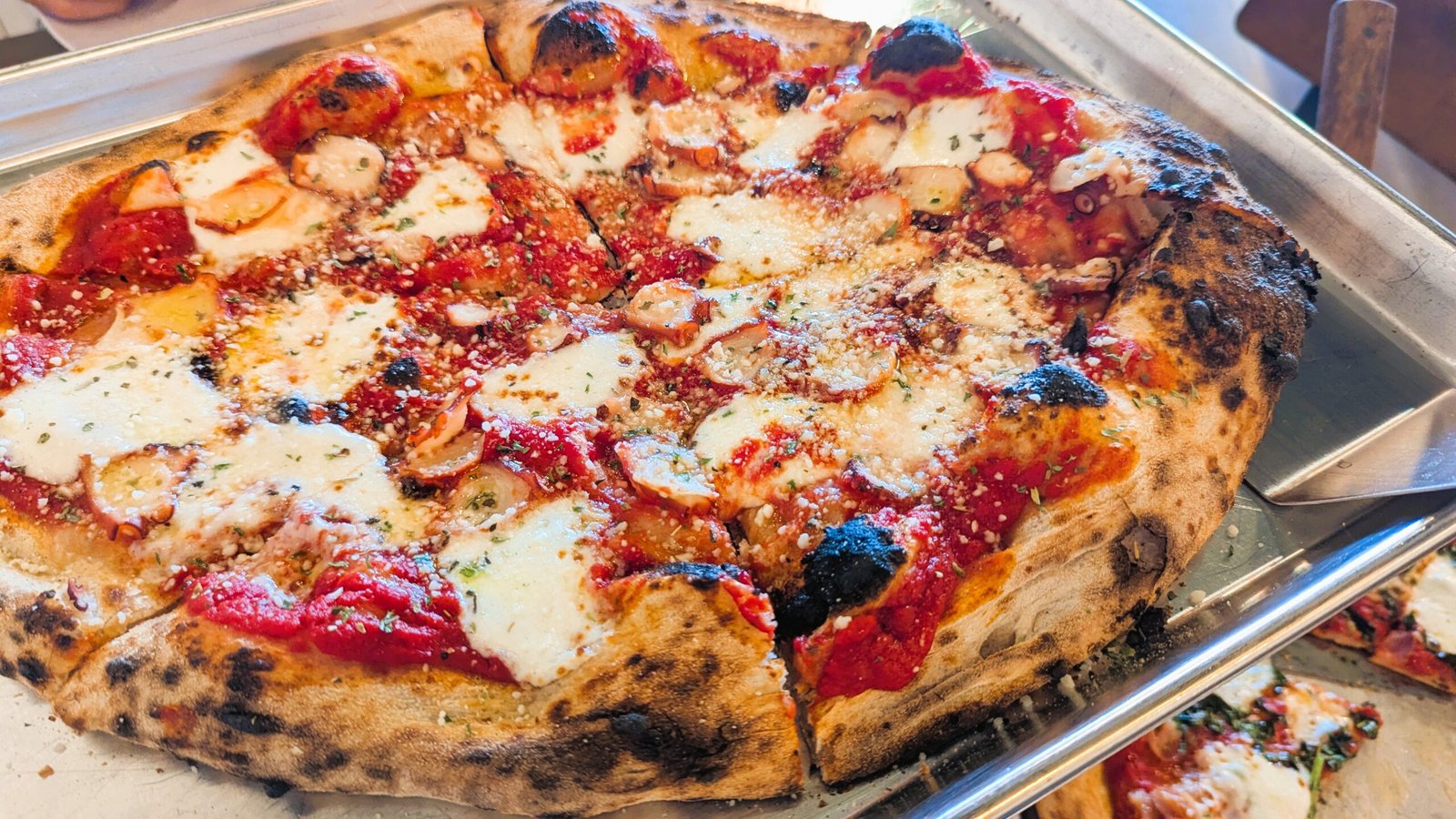 Sardegna: Pizza topped with thinly sliced, perfectly grilled octopus, fresh mozzarella, garlic, and parsley. Finished with Pecorino Romano and a drizzle of EVOO